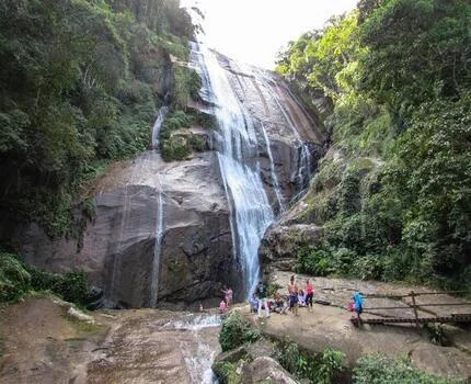 pessoas em cima da pedra da cachoeira do gato em ilhabela